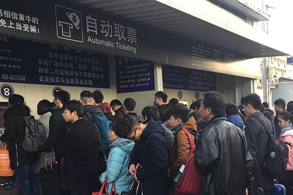 Many passengers lineup to pick up their train tickets at the station.